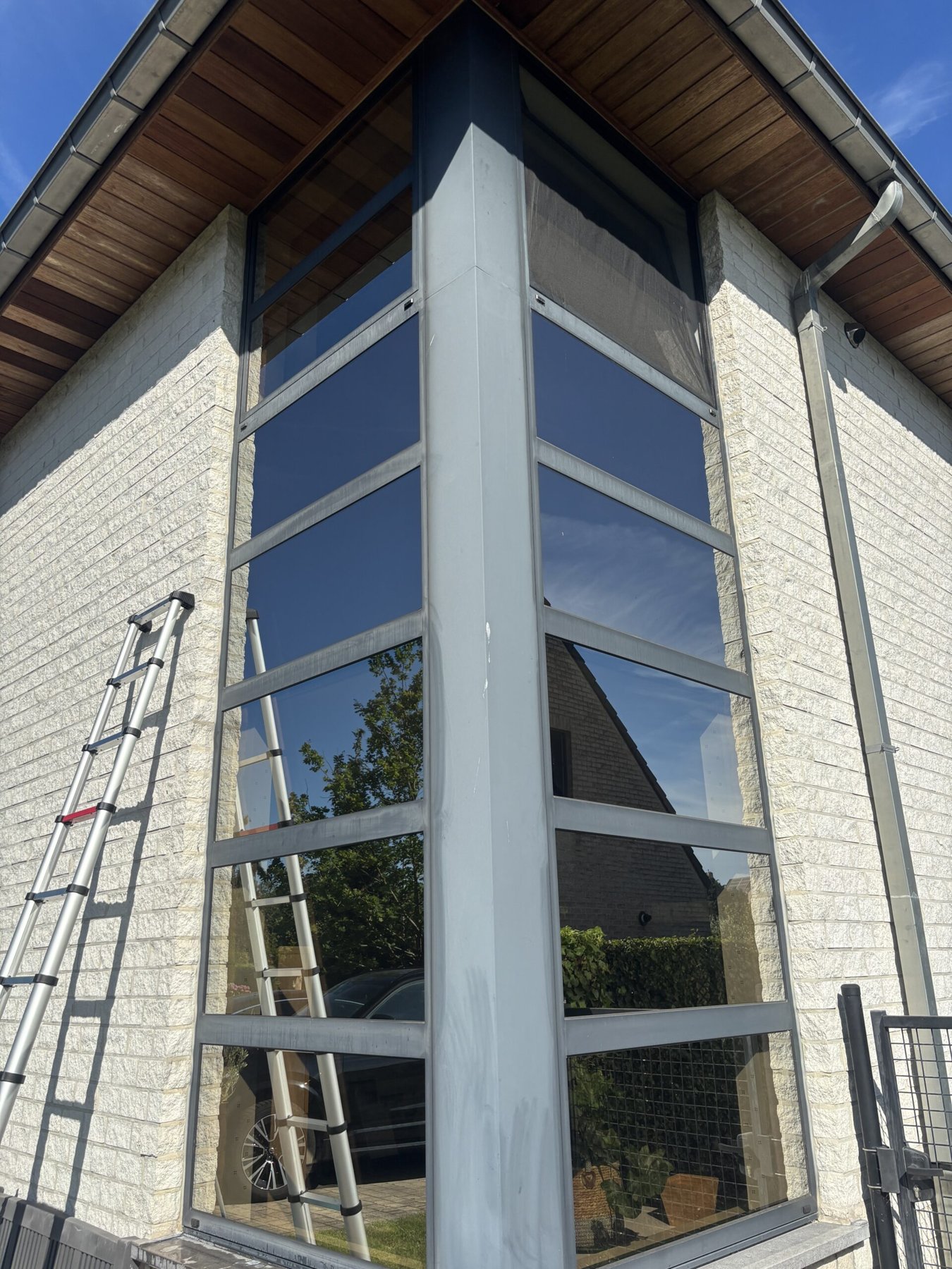 Glazen gevel met ladder bij een raamreinigingsproject